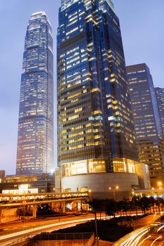 It is skyscraper with traffic light and cars motion blurred in Hong Kong.