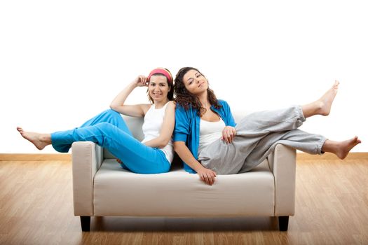 Two beautiful young women's sitting on a sofa