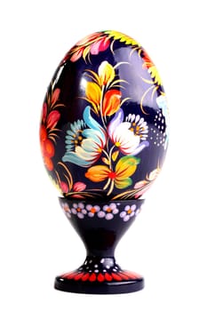 Wooden painted egg in style of Russian varnish list on a support. On egg flowers a symbol of the Russian village are drawn.