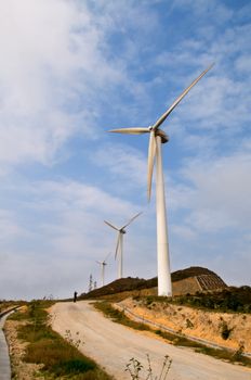 White electrical power generating wind turbines on rolling hills