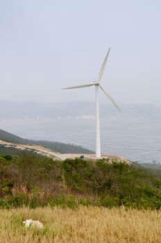 White electrical power generating wind turbines on rolling hills