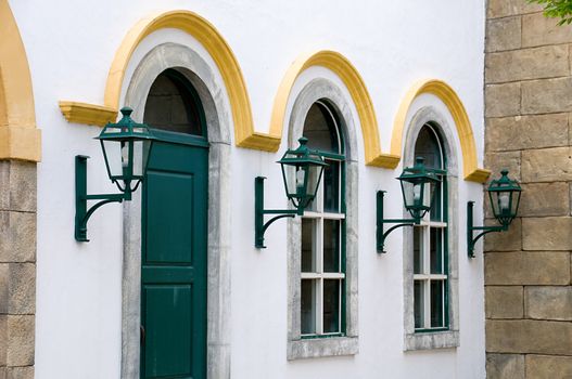 A facade shot of windows and antique lanterns