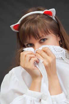The young sexy woman coquettishly hides the face behind a lacy collar