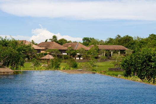 Villas and swimming pool in green field of India