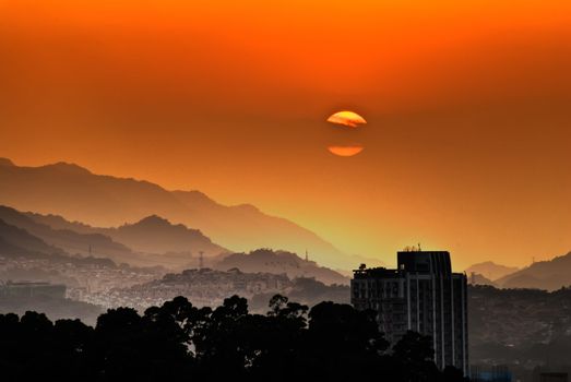 City sunset scenery with buildings and apartments silhouette.