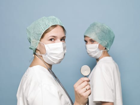 Two female nurses with surgical masks and a stethoscope