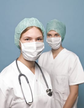 Two nurses with surgical masks and a stethoscope