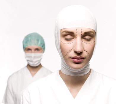 Woman prepared for plastic surgery with a nurse at her back