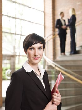 Businesswoman in front of two women in the stairs