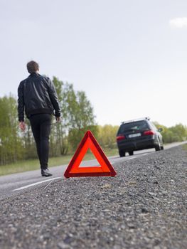 Warning triangle in front of a car breakdown