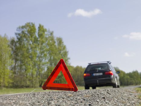 Warning triangle in front of a car breakdown