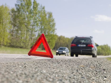 Warning triangle in front of a car breakdown