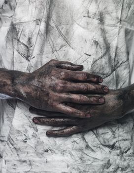 Very dirty hands in front of a dirty shirt