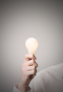 Hand holding shining light bulb