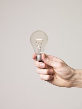 Hand holding shining light-bulb