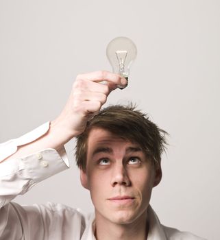 Man holding electric light bulb over his head