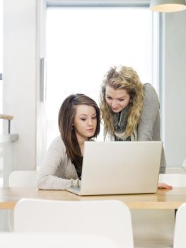 two girls using a laptop