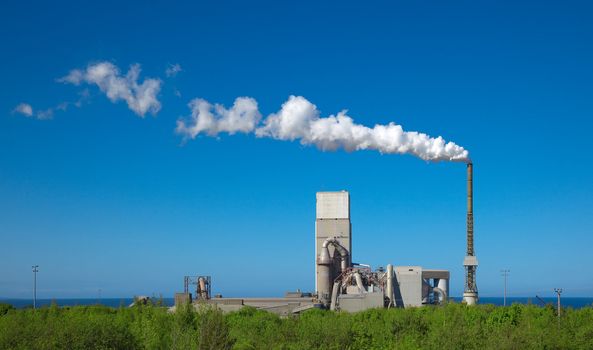 A photography of a cement plant under a blue sky