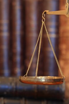 Closeup of ancient weight scale on background with old books