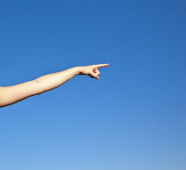 A photography of a nice girl pointing in front of a blue sky