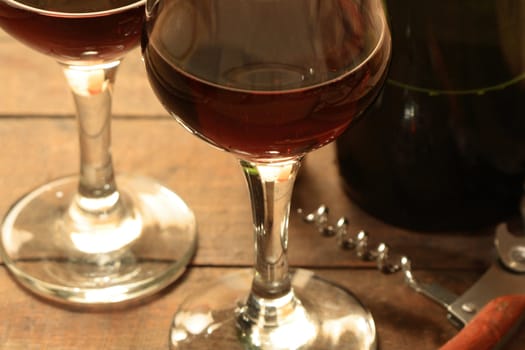 Closeup of two wineglasses with red wine on wooden background