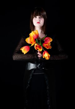 Pretty goth girl in black dress with plastic tulips