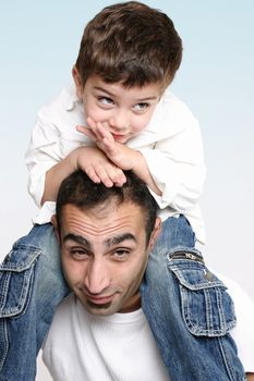 A child happily relaxes sitting on father's shoulders