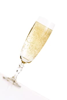 Celebration.  An angled glass of champagne in a champagne flute glass.