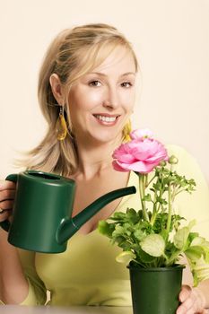 Enthusiastic Gardener with a flowering plant of pretty pink blooms and buds.