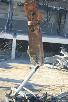 Crane picking up debris from a construction site.