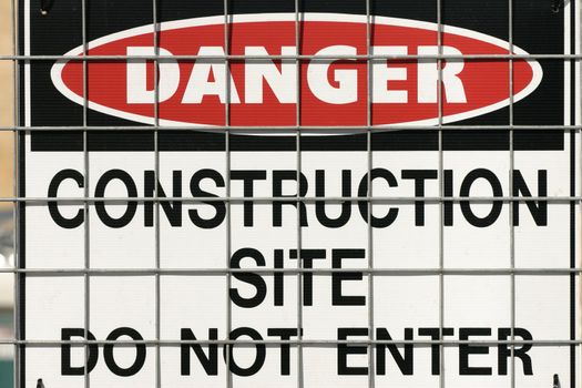 Warning building construction sign on fence. 