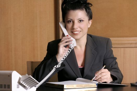 Professional woman at work desk on the phone.

