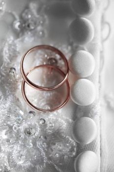 Wedding rings on a background of a wedding dress.