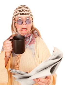 Crazy new age woman in a yellow robe with coffee cup and newspaper