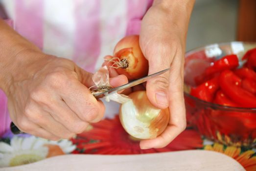woman hands closeup pilling onion in kitchen