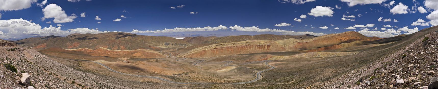 Wide panorama of a rocky desert taken on the northwest region of Argentina. You can see the salt lake far behind the mountains.