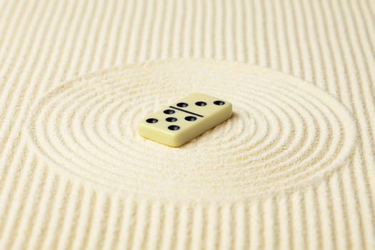 Dominoes on a surface of yellow sand - an abstract composition