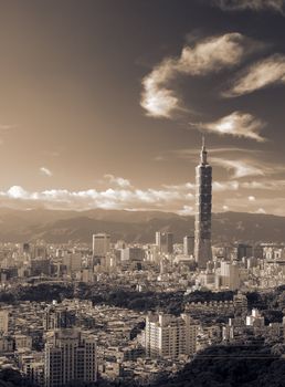 Landmark of Taipei skyscraper with golden sunset and white clouds fly.