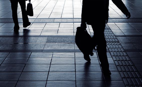 Businessman silhouette carry briefcase and walk in corridor in motion blurred.