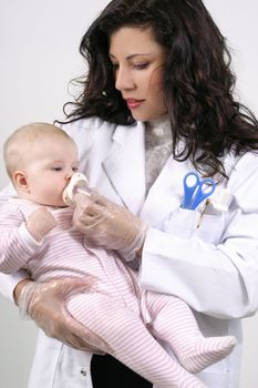 A doctor medicates a baby using a measured dose