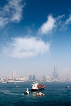 Harbor scenery with freighter and cargo ships and skyscraper in Kaohsiung, Taiwan.