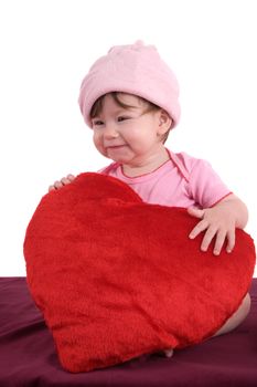 Cute little baby having fun and laughing while holding a big red heart