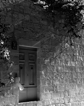 Typical limestone Mediterranean house facade with bouganvilla