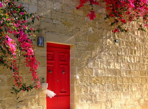 Typical limestone Mediterranean house facade with bouganvilla