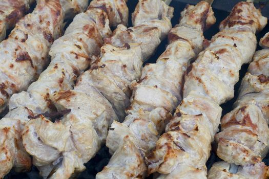 Appetizing shish kebab on the grill with metal skewers