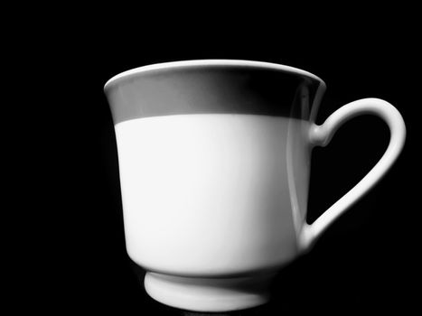 Fine china tea-cup shot in monochrome, over black background