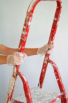 Young woman climbing on a step ladder