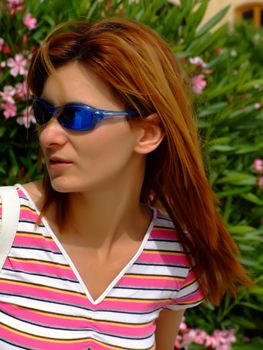 Woman wearing sunglasses, walking in street and worried of being followed