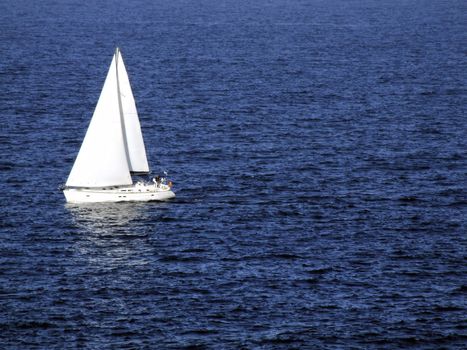 Sailing boat travelling along calm blue waters