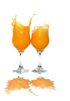 Two goblets of splashing orange juice isolated on white background with clipping path